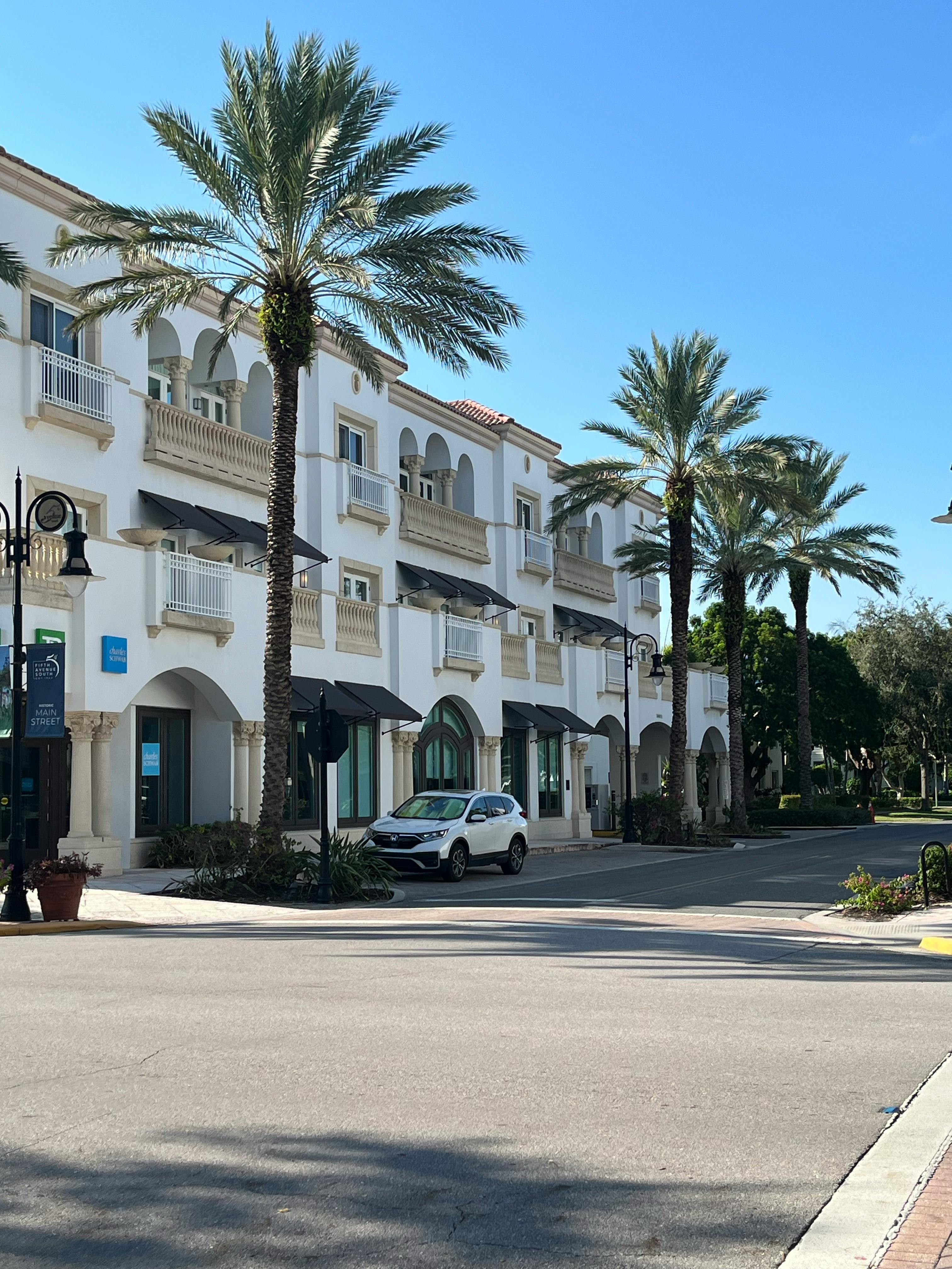 Scenic street view with palm trees and historic architecture in Naples, Florida.